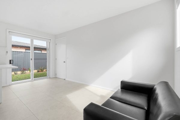Lounge room with sliding door to the backyard at the Beyond Care Fairfield West SIL home